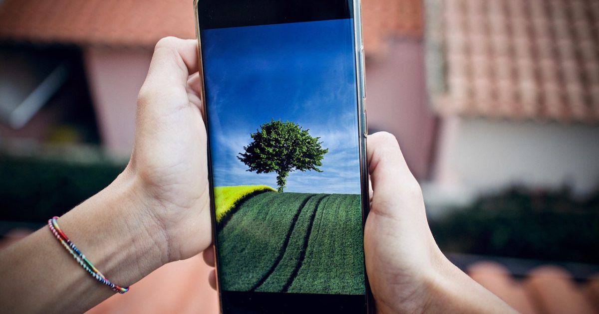 精粤主板 App 主界面在手机屏幕上的展示，深色背景中排列着型号检索框、BIOS 参数卡片与装机进度条目，整体氛围沉稳专业